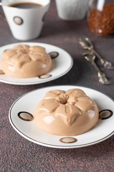 Sobremesa de café feita de creme e gelatina em moldes de porção no fundo marrom. Sobremesa Blancmange — Fotografia de Stock