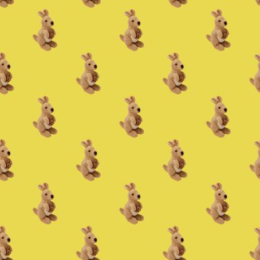 Duvar kağıdı, kumaş ya da ambalaj kağıdı için parlak sarı arka planda bebeği olan kusursuz desenli anne kanguru.