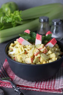 Yaban mersinli salata, kereviz, elma ve bıldırcın yumurtası gri arka planda, dikey formatta.