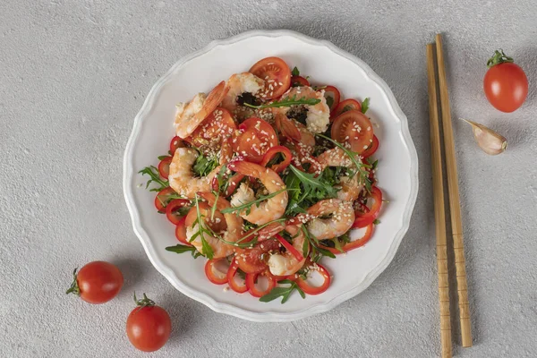Salad of Shrimps, Arugula, Cherry tomatoes, Sweet peppers and Sesame seeds on white plate — Fotografie, imagine de stoc