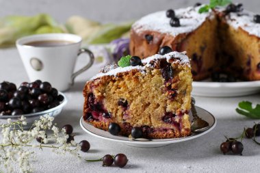 Siyah üzümlü ev yapımı turta ve açık gri arkaplanda kesim