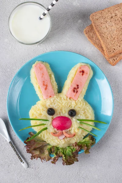 Funny bunny from mashed potato and sausages, natural yogurt in glass and bread for breakfast kids meal. Creative children\'s menu, Vertical format