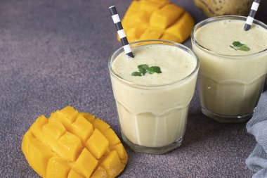 Kahverengi arka planda gözlüklü Mango Lassi. Taze Hint Lassi 'si yoğurttan, sudan, baharatlardan, mangodan ve buzdan yapılır.