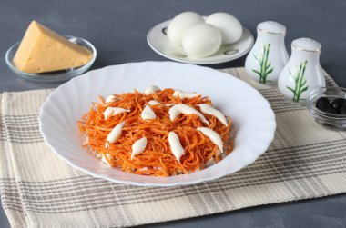 Katmanlı salata hazırlığı. Doğranmış tavuk göğsünü bir tabağa koy, sonra havuçları, mayonez yağıyla. Adım adım.