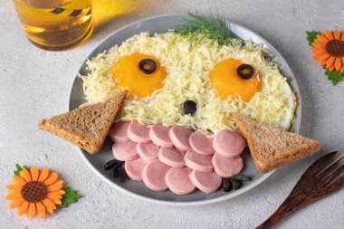 Çocuklar için eğlenceli yiyecekler. Peynirli yumurta, sosis ve ekmekten komik baykuş. Yaratıcı, sağlıklı kahvaltı, yakın çekim.