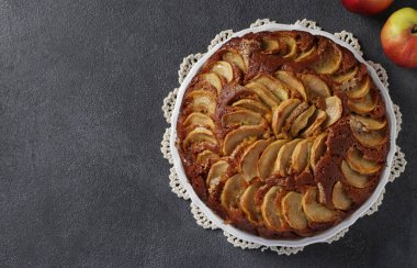 Ev yapımı Charlotte turtası, gri arka planda beyaz plakalı elmalar, Üst Manzara, Boşluğu Kopyala