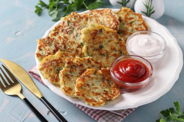 Peynirli, sarımsaklı ve maydanozlu kızarmış patates gözlemesi. Kahvaltıda ekşi krema ve domates sosuyla servis ediliyor.