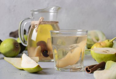 Cam tarçınlı taze armutlar ve gri arka planda sürahi.