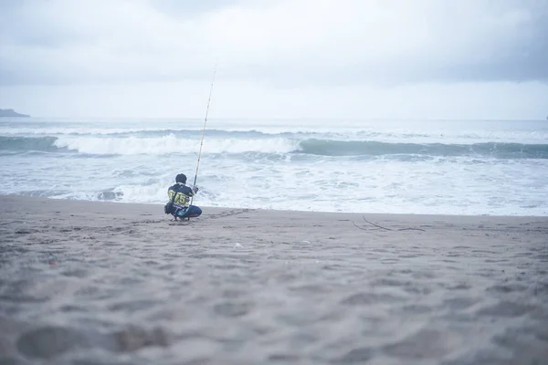 2021年10月25日 印度尼西亚 太平洋 一名男子使用长钓竿在海岸线上捕鱼 他在沙滩上垂钓以消磨时间 — 图库照片