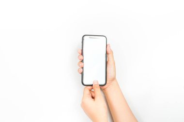 İki elini kullanarak boş ekranlı bir cep telefonu tutuyor. Reklam için kullanılan beyaz ekranlı bir akıllı telefon..