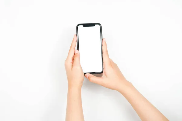 Akıllı telefonu iki elle tutmak. Reklam için kullanılan beyaz ekranlı bir akıllı telefon..
