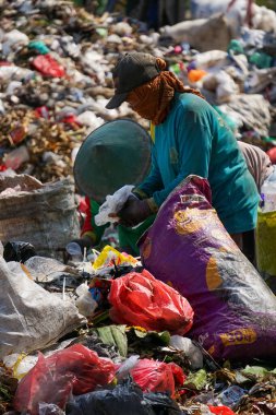 Ponorogo, Endonezya - 10 08 2021: çöplükte birisi plastik çöpleri ayırıp çuvala koyuyor.. 