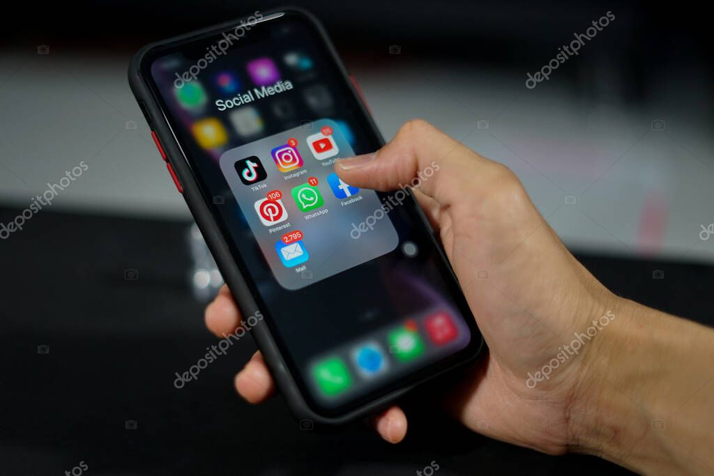 Ponorogo, Indonesia - 10 11 2021: a hand holds a smartphone opening a social media folder. the most used social media for networking with people at a distance.