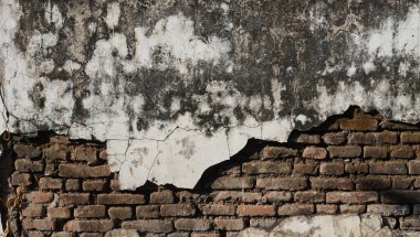 Yıpranmış beton ve tuğla duvarın yarısı dökülmüş. Grunge arkaplan dokusu için eskimiş duvar. Yaratıcı sokak tasarım elementleri için eski doku.