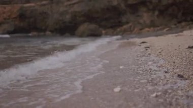Okyanusun sakin dalgası kumsala doğru ilerliyor. Karaya akan deniz suyunun yan görüntüsü. Sinematik video için doğanın görüntüleri.