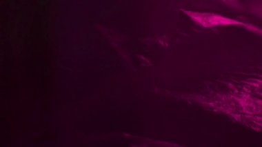 Pembe neon ışık desenli buruşuk plastik dokuyu sallıyor. Video ses sunumu için gerçekçi plastik görüntüler.
