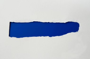 Kıvrık kenarlı yırtık kağıt. Beyaz kağıtta uzun mavi bir yırtık var. Kopyalama alanı ve metin için yırtık kenarlı gerçekçi yırtık kağıt.