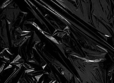 Siyah arka planda şeffaf bir plastik ambalaj. Kaplama ve etki için gerçekçi plastik ambalaj dokusu. Yaratıcı ve dekoratif tasarım için buruşuk plastik desen.