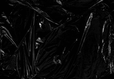 Siyah arka planda şeffaf bir plastik ambalaj. Kaplama ve etki için gerçekçi plastik ambalaj dokusu. Yaratıcı ve dekoratif tasarım için buruşuk plastik desen.