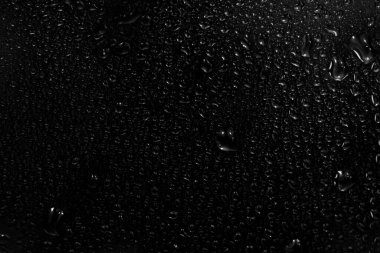 Su damlaları siyah arkaplanda. Fotoğraf kaplama efekti için pencere camındaki çiğ damlacıkları ya da içecek modelleri üzerinde taze etki yaratmak için.