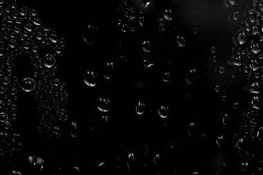 Su damlaları siyah arkaplanda. Fotoğraf kaplama efekti için pencere camındaki çiğ damlacıkları ya da içecek modelleri üzerinde taze etki yaratmak için.