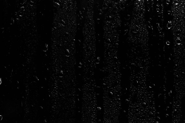 water drops on black background. abstract dew water droplets on a window glass for photo overlay effect or giving fresh effect on beverages mockup.