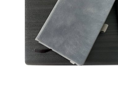 Defter masanın üstünde. Her şeyi kaydetmek için küçük gri bir defter. Fikirler ve temel şeyler de dahil. Dağıtıcıyla kapat.