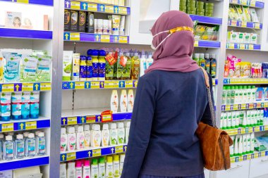 Ponorogo, Jawa Timur / Endonezya - 08 27 2020: maskeli kadınlar, Covid-19 salgını sırasında bir alışveriş merkezinde durup güzellik ürünlerine bakıyorlar.