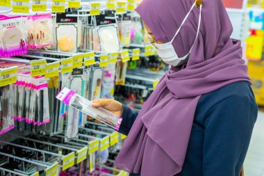 Ponorogo, Jawa Timur / Endonezya - 08 27 2020: maskeli kadınlar, Covid-19 salgını sırasında bir alışveriş merkezinde durup güzellik ürünlerine bakıyorlar.