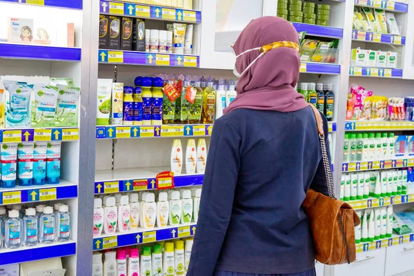 Ponorogo, Jawa Timur / Endonezya - 08 27 2020: maskeli kadınlar, Covid-19 salgını sırasında bir alışveriş merkezinde durup güzellik ürünlerine bakıyorlar.