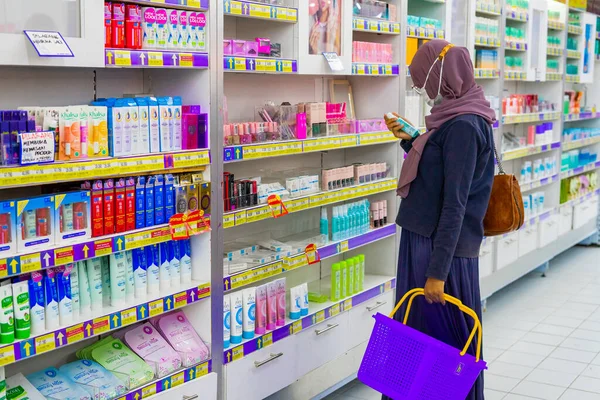 Ponorogo, Jawa Timur / Endonezya - 08 27 2020: maskeli kadınlar, Covid-19 salgını sırasında bir alışveriş merkezinde durup güzellik ürünlerine bakıyorlar.