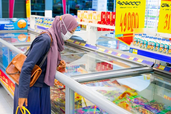 Ponorogo, Jawa Timur / Endonezya - 08 27 2020: Alışveriş merkezlerinde maske takan, malzeme, et ve baharat seçen kadınlar. Müslüman ev kadınları covid-19 salgını sırasında market alışverişi yapıyor..