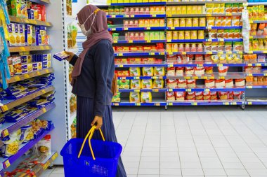 Ponorogo, Jawa Timur / Endonezya - 08 27 2020: Alışveriş merkezlerinde maske takan, malzeme, et ve baharat seçen kadınlar. Müslüman ev kadınları covid-19 salgını sırasında market alışverişi yapıyor..