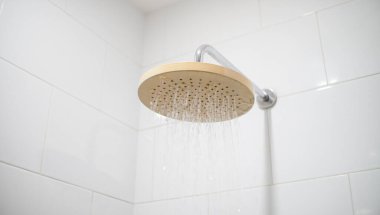Kafa banyosu musluğundan akan su. Estetik banyo içi su döküyor. Yerli su kullanımının gösterimi için minimalist iç mekan.