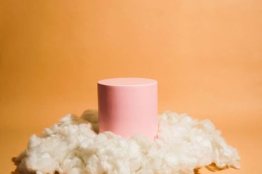 Bulut şeklinde pamukla süslenmiş pembe pastel renkli ürün platformu düzenlemesi. Kozmetik, cilt bakım ürünleri veya diğer ürünleri göstermek için boş bir podyumu olan moda ekran düzeni.