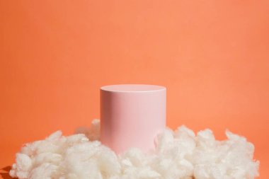 Bulut şeklinde pamukla süslenmiş pembe pastel renkli ürün platformu düzenlemesi. Kozmetik, cilt bakım ürünleri veya diğer ürünleri göstermek için boş bir podyumu olan moda ekran düzeni.