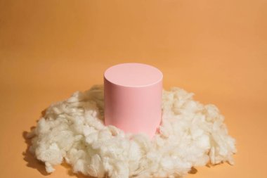 Bulut şeklinde pamukla süslenmiş pembe pastel renkli ürün platformu düzenlemesi. Kozmetik, cilt bakım ürünleri veya diğer ürünleri göstermek için boş bir podyumu olan moda ekran düzeni.