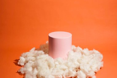 Bulut şeklinde pamukla süslenmiş pembe pastel renkli ürün platformu düzenlemesi. Kozmetik, cilt bakım ürünleri veya diğer ürünleri göstermek için boş bir podyumu olan moda ekran düzeni.