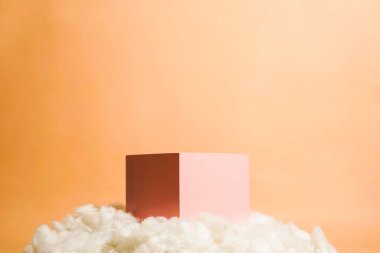 Bulut şeklinde pamukla süslenmiş pembe pastel renkli ürün platformu düzenlemesi. Kozmetik, cilt bakım ürünleri veya diğer ürünleri göstermek için boş bir podyumu olan moda ekran düzeni.
