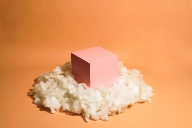 Bulut şeklinde pamukla süslenmiş pembe pastel renkli ürün platformu düzenlemesi. Kozmetik, cilt bakım ürünleri veya diğer ürünleri göstermek için boş bir podyumu olan moda ekran düzeni.