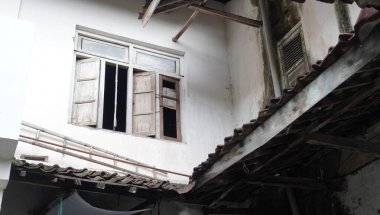 Terk edilmiş bir binanın ikinci katı. Pencereleri açık olan eski bina. Ürkütücü nüanslı bir bina..