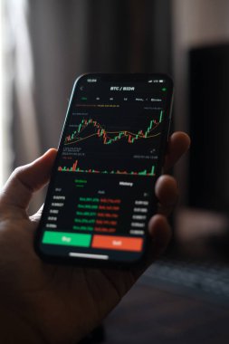 Ponorogo, Endonezya - 01 29 2022: cep telefonu kullanarak pazar güncellemelerini analiz etmek. Hisse senedi veya kripto para hareketini resimlemek için bir fotoğraf.