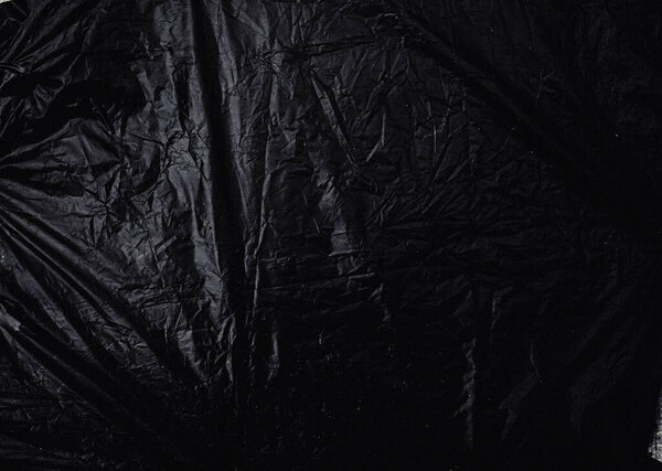 a transparent stretch plastic wrap on black background. realistic plastic wrap texture for overlay and effect. wrinkled plastic pattern for creative and decorative design.