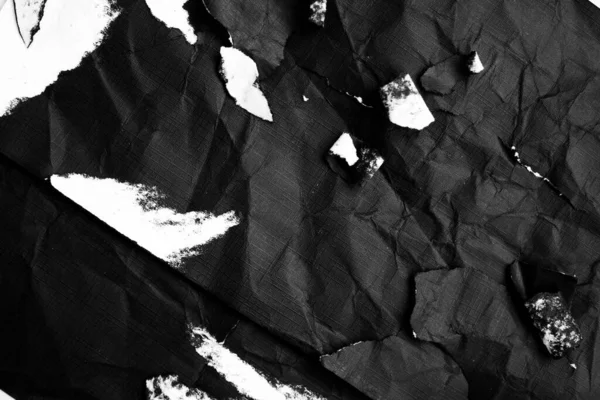 Black paper with white tears for the background. Crumpled paper texture with messy tears.