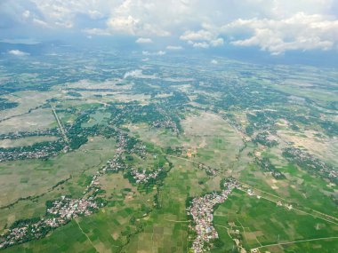 Hava manzarası şehrin yeşil bir manzarasını gösteriyor. Sokaklar, pirinç tarlaları ve köy evleri..