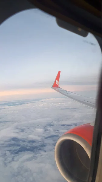 飛行機の窓からの眺め 白い雲と青い背景の空 太陽の光が差し込み 航空機の翼が明らかになる天気 — ストック写真