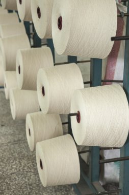 raflar içinde üst üste pamuk makaraları
