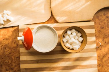 Şeker ve rafine şeker masadaki şeker kasesine dökülür..