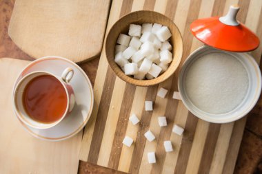 Şeker ve rafine şeker, bir fincan çay, masanın üstünde bir fincan çay..