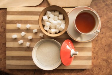 Şeker ve rafine şeker, bir fincan çay, masanın üstünde bir fincan çay..